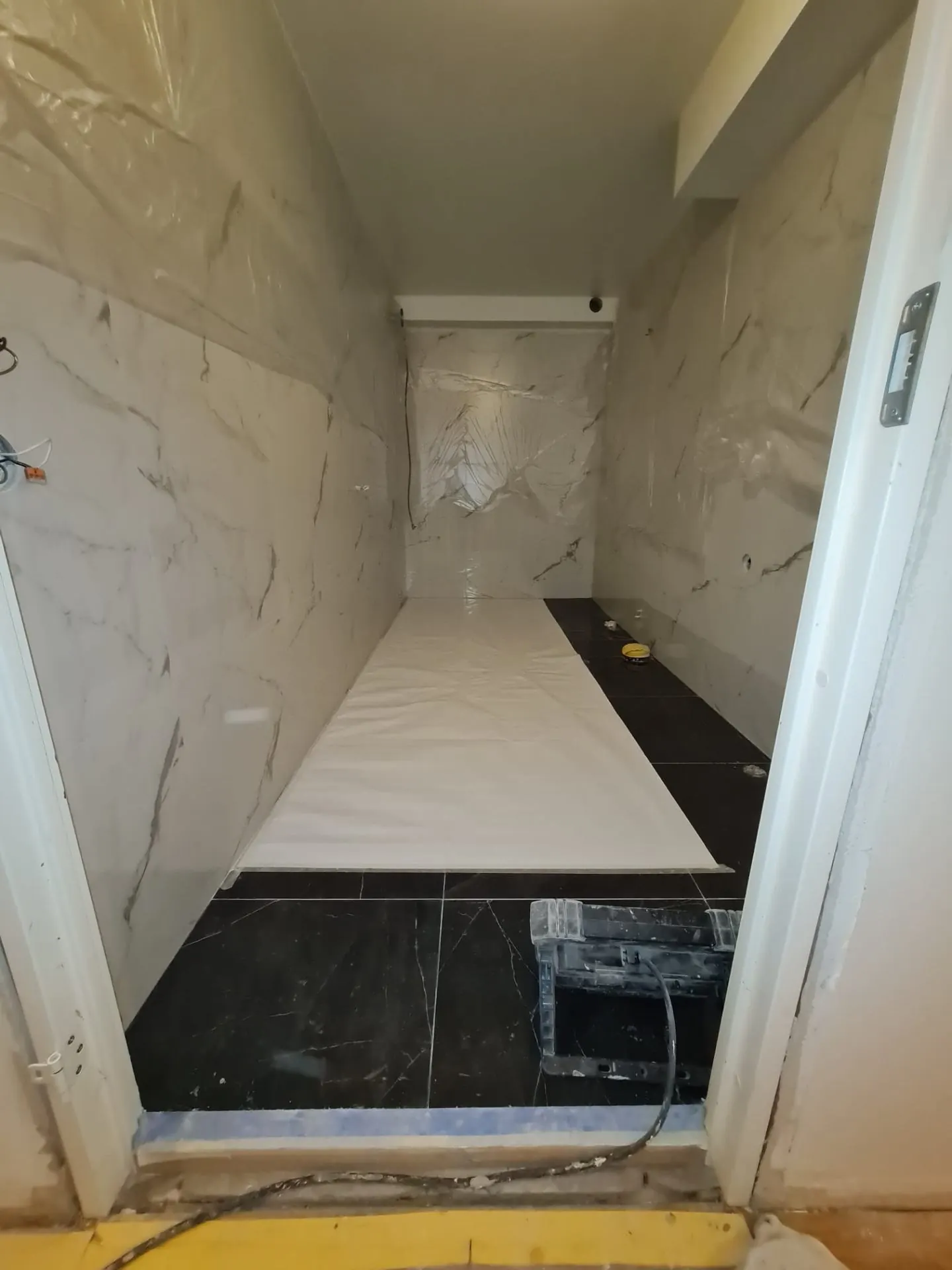 Pågående installation — golvplattor och tätskikt på plats